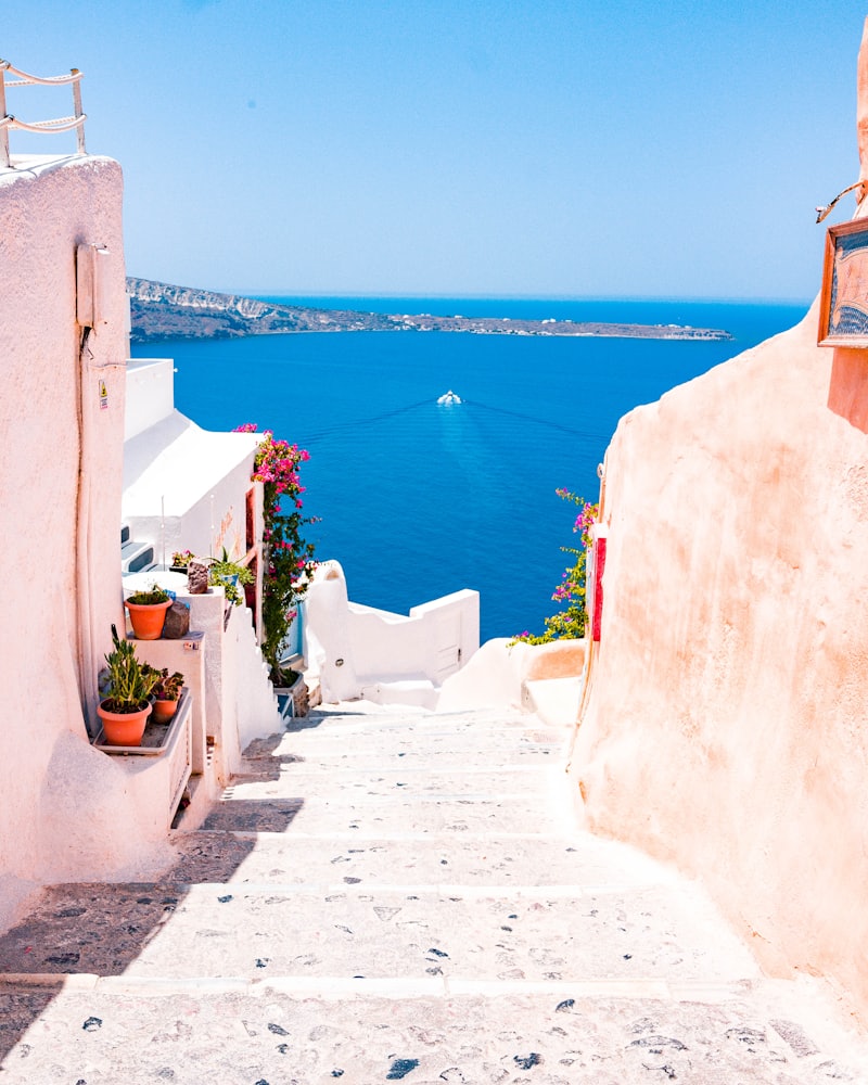 Whitewashed steps running down to the caldera at Santorini, deep blue sea beyond